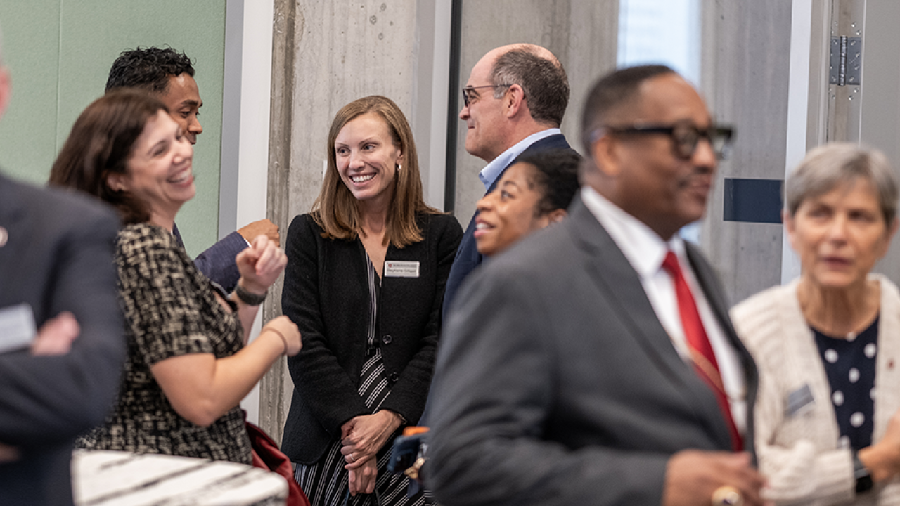 Group of individuals in business professional attire having conversation at an event. 